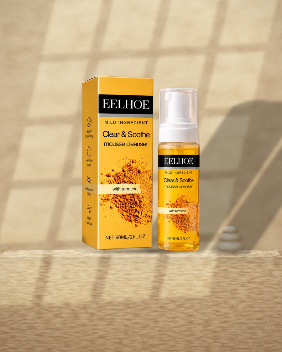 Turmeric Foaming Cleanser on a travertine ledge in window light